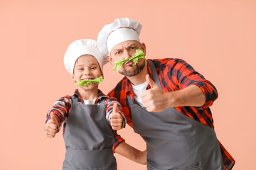 father and son in chef hats cooking greens